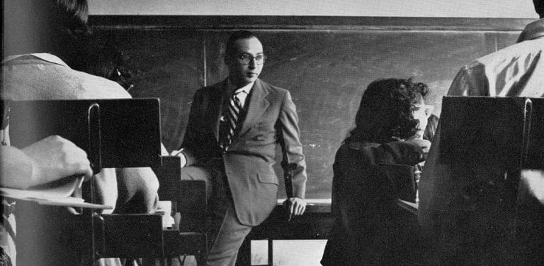 Professor seated in front of class "chock full of knowledge," 1951