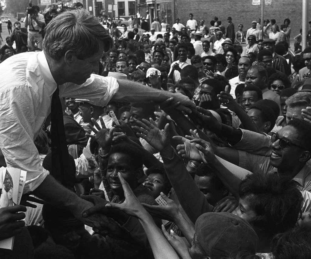 Robert Kennedy reaches into a crowd while campaigning in Detroit